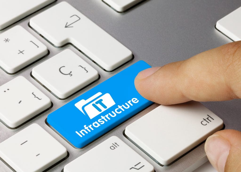 A person is pressing a key on a keyboard that says IT Infrastructure