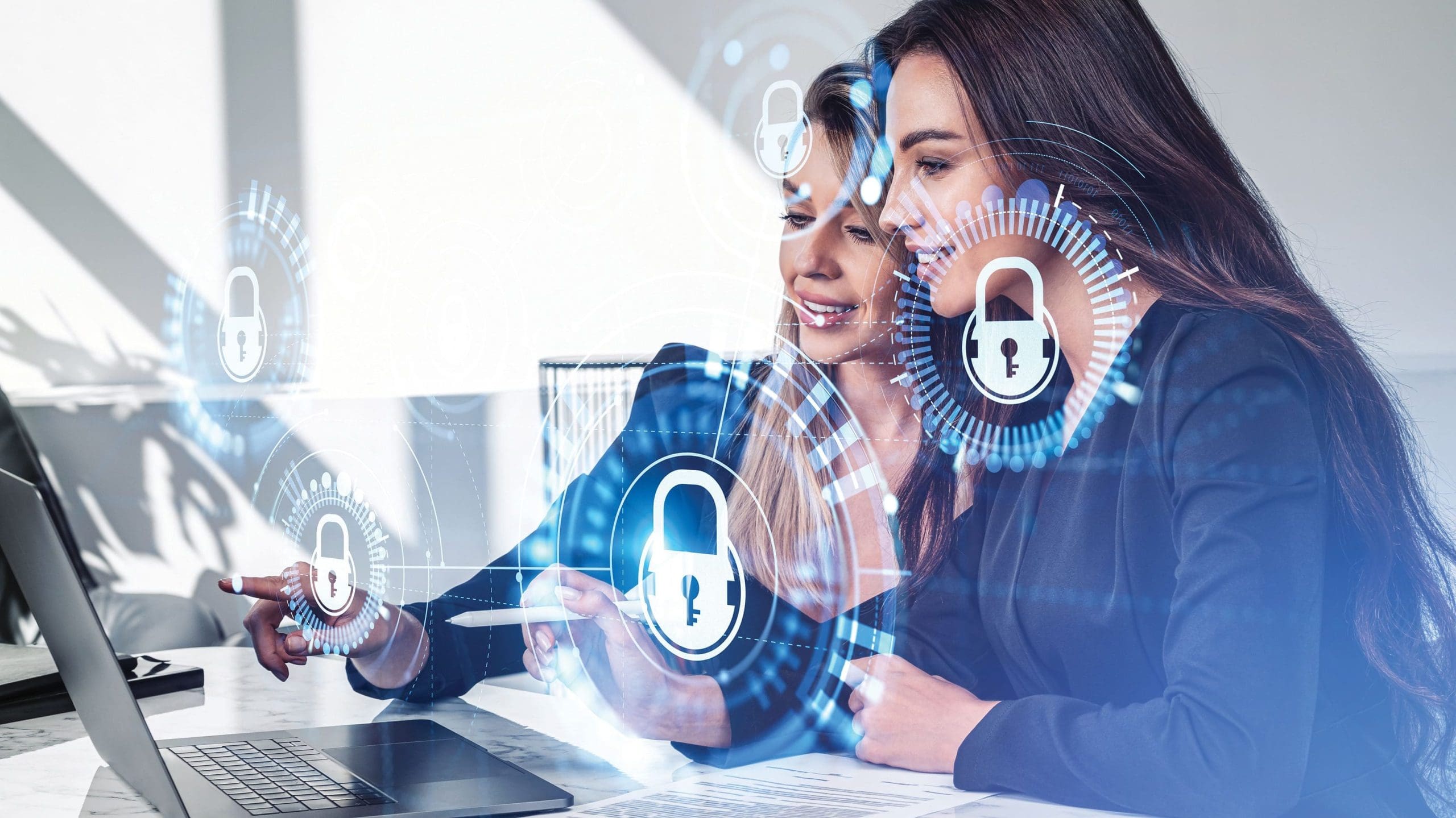 Two businesswomen working with laptop, hologram with lock and chain