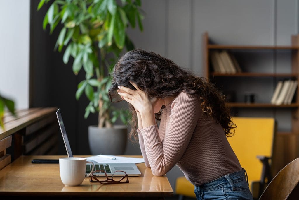 a woman sitting at her computer looking frustrated